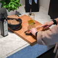 Bild in Galerie-Betrachter laden, Hackbrett aus Eichenholz, Antirutschkante, hochkant 34 x 50 x 3,5 cm, rechts unten Logo von COOKX eingraviert, Milieubild in Küche, Brett liegt auf Kücheninsel, Karotten auf Brett geschnitten, Ansicht oben