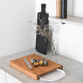 Bild in Galerie-Betrachter laden, Hackbrett aus Holz Natur, Auffangöffnung für Teller, Milieubild in Küche, weißer Teller in Auffangöffnung, Messer und Früchte liegen auf Brett