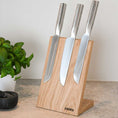 Bild in Galerie-Betrachter laden, Messerblock aus Eichenholz Natur, magnetisch, Messerblock schräg nach hinten geneigt, Milieubild in Küche, drei Messer am Messerblock, links daneben Basilikumpflanze