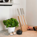 Bild in Galerie-Betrachter laden, Messerblock aus Eichenholz Natur, magnetisch, Messerblock schräg nach hinten geneigt, Milieubild in Küche, drei Messer am Messerblock, links daneben Basilikumpflanze, Ansicht von links