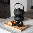 Bild in Galerie-Betrachter laden, Kerzentablett aus Eichenholz schwarz, 28 x 14 x 2,3 cm, Milieubild in Küche, auf Tablett liegen Gebäck und Früchte, Löffel und kleine schwarze Schüssel mit Teebeutel, im Hintergrund steht Teekanne