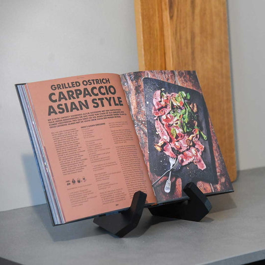 Buchständer in X-Form aus schwarzer Eiche, minimalistisches Design mit geschwungenen Haken-Enden mit Buch drauf