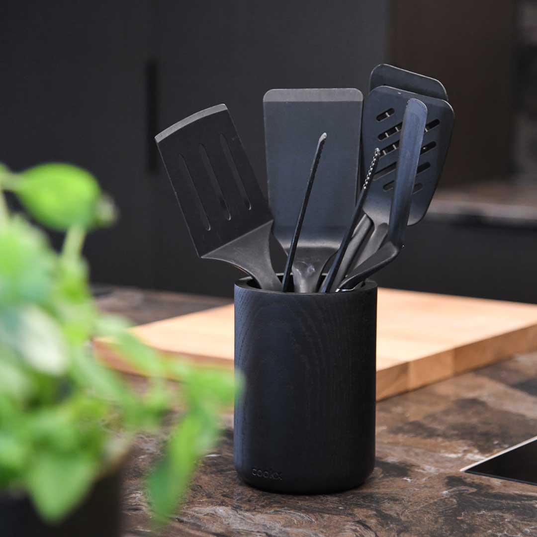 Küchenutensilienhalter aus Eichenholz schwarz, Milieubild in Küche, im Halter sind schwarze Küchenutensilien